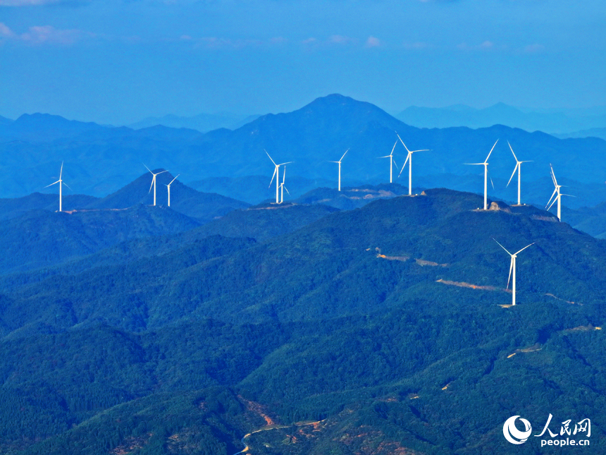贛州市定南縣歷市鎮群山之上，風力發電機迎風旋轉，轉化為清潔電源并入電網輸往工廠企業、千家萬戶。人民網 朱海鵬攝