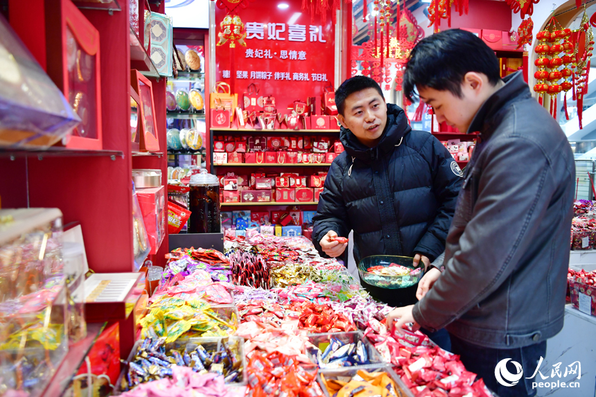 市民正在新洪城大市場的糖果店鋪內選購年貨。 人民網記者 時雨攝