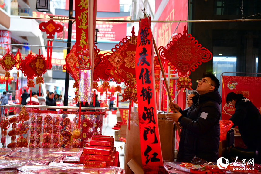 新洪城大市場內，店主正在懸掛對聯。 人民網記者 時雨攝