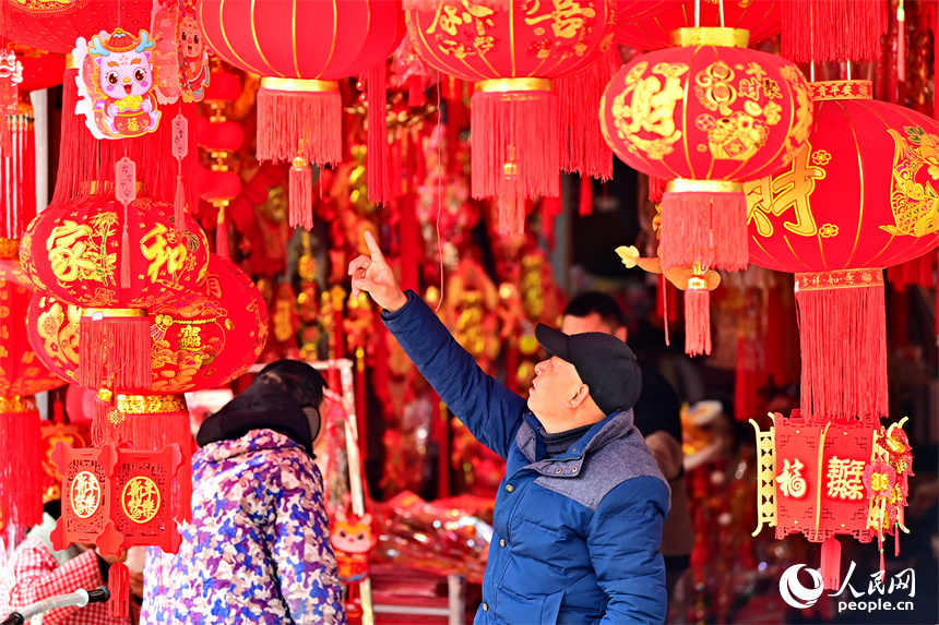 贛州市贛南貿易廣場的喜慶飾品店，市民在選購春聯、燈籠、福字。人民網 朱海鵬攝