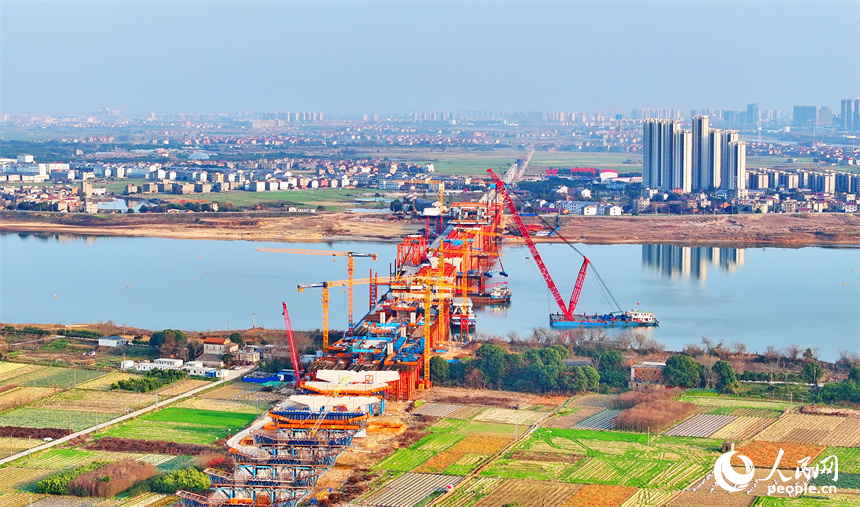 南昌市東湖區揚子洲鎮贛江河畔塔吊矗立，設備有序運轉，工人在隆興大橋項目工地忙碌。人民網 朱海鵬攝