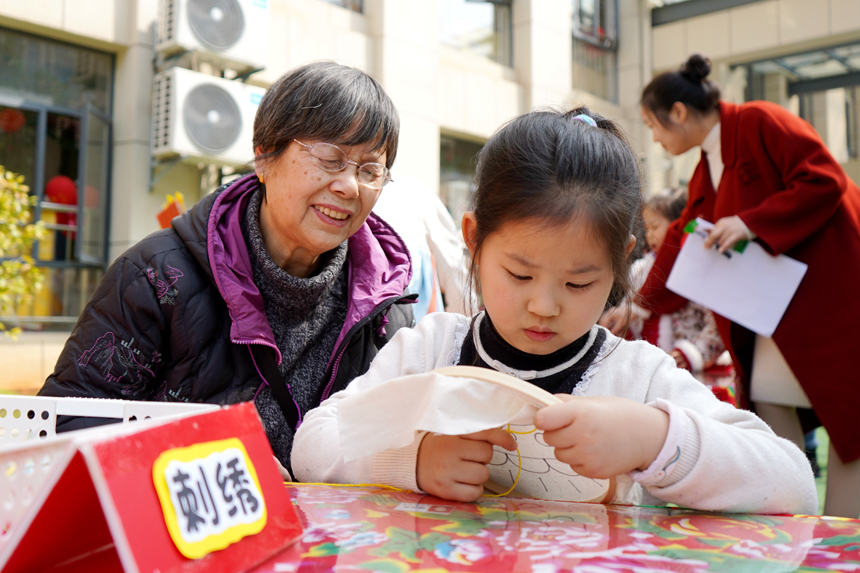 孩子在家長的指導下學刺繡。陳旗海攝