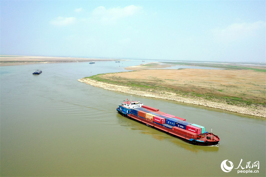 滿載著集裝箱的貨運船只從鄱陽湖進入贛江，駛向上游目的地港口。 人民網記者 時雨攝