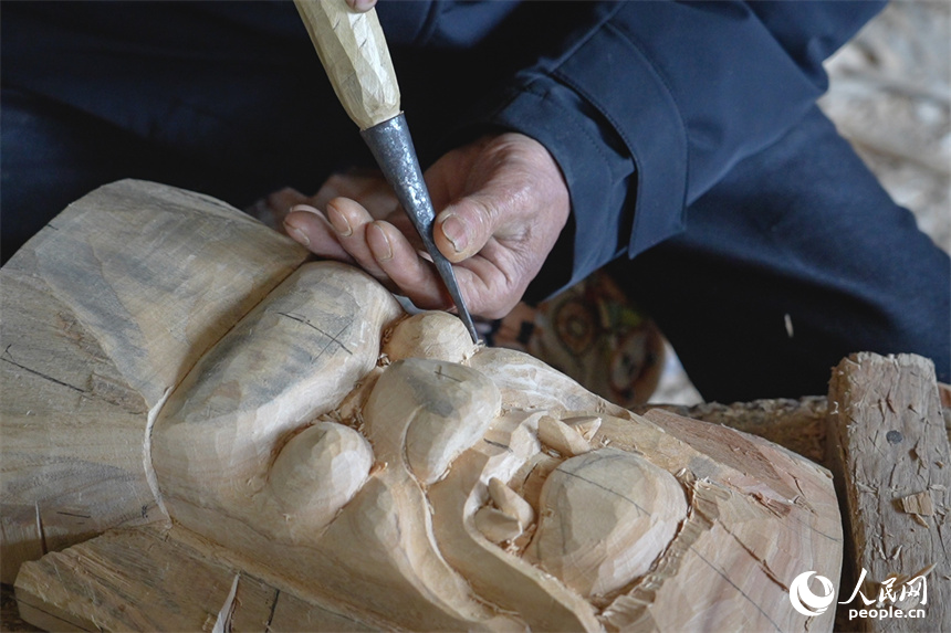 國家級非遺傳承人賴明德正在修飾儺面具的眼睛。人民網 孔文進攝