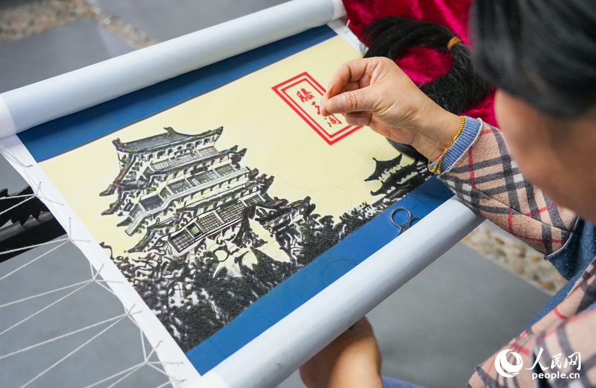 在贛發繡非遺展示中心，陶永紅正在用發絲繡《滕王閣》圖。人民網 孔文進攝