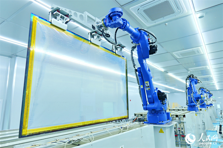 一排排智能機器人正轉動機械臂加工透明導電膜。人民網 朱海鵬攝