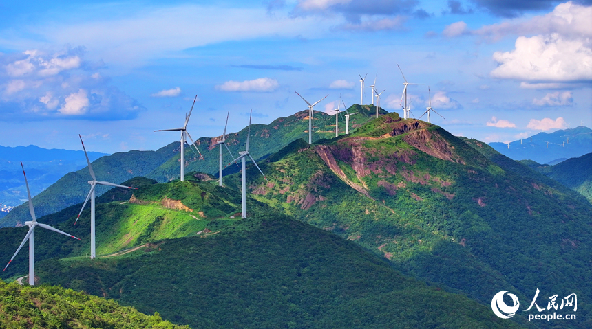 贛州市安遠縣九龍山風力發電場，隨風轉動的發電機組與藍天、白云、綠樹、青山交相輝映。人民網 朱海鵬攝