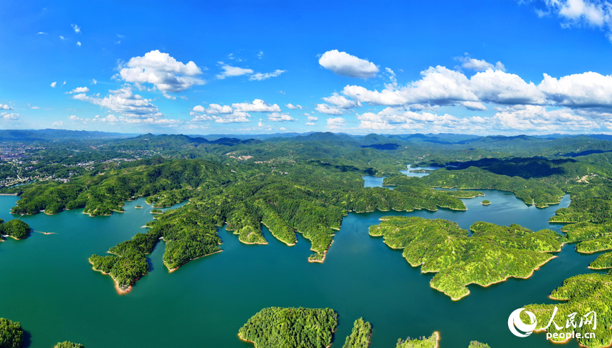 贛州市會昌縣石壁坑水庫波光粼粼，藍天白云與澄凈湖水交相輝映，構成一幅綠色生態山水畫卷。人民網 朱海鵬攝