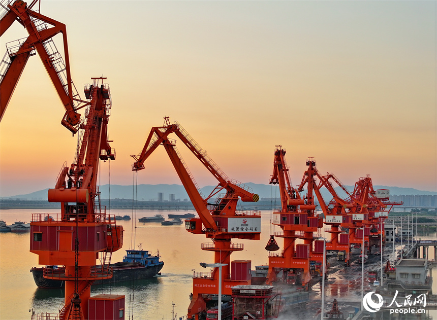 位于南昌市南昌縣的姚灣綜合碼頭，貨船、貨車來來往往，起重機裝卸作業有序進行，呈現出忙碌的景象。人民網 朱海鵬攝