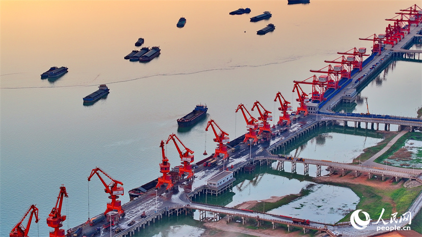 位于南昌市南昌縣的姚灣綜合碼頭，貨船、貨車來來往往，起重機裝卸作業有序進行，呈現出忙碌的景象。人民網 朱海鵬攝