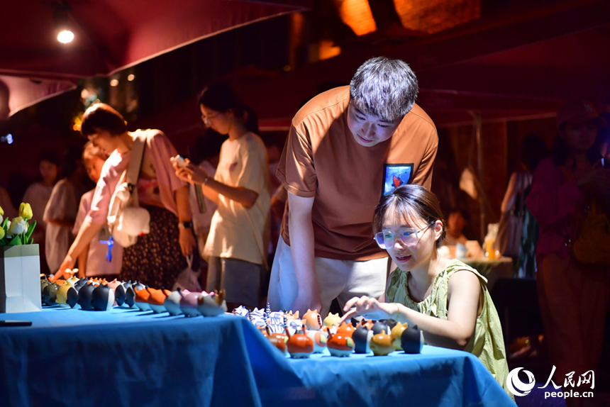 夜市上，游客們在挑選心儀的瓷器產品。人民網記者 時雨攝