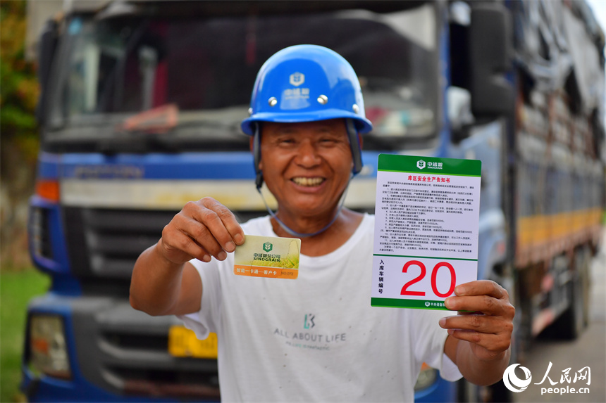 糧農展示通過預約后拿到的入庫次序牌和售糧“一卡通”。人民網記者 時雨攝