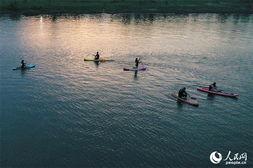 在贛江紅谷灘水域，水上運動愛好者們劃著槳板享受著水上運動帶來的樂趣。人民網記者 時雨攝