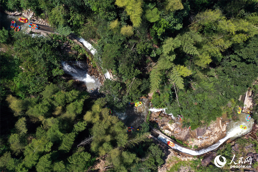 上高縣峽谷漂流水道上色彩斑斕，游客們在漂流艇上戲水消暑。人民網記者 時雨攝