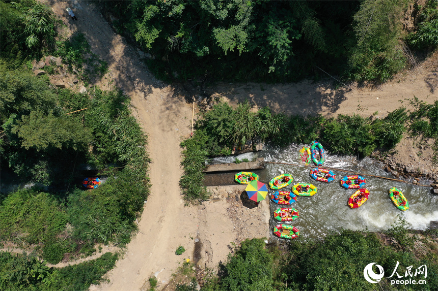 上高縣峽谷漂流水道上色彩斑斕，游客們在漂流艇上戲水消暑。人民網記者 時雨攝