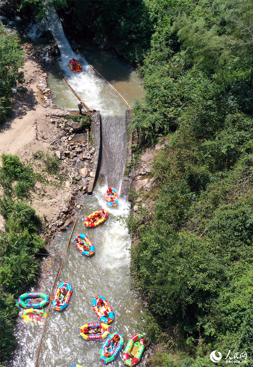 上高縣峽谷漂流水道上色彩斑斕，游客們在漂流艇上戲水消暑。人民網記者 時雨攝