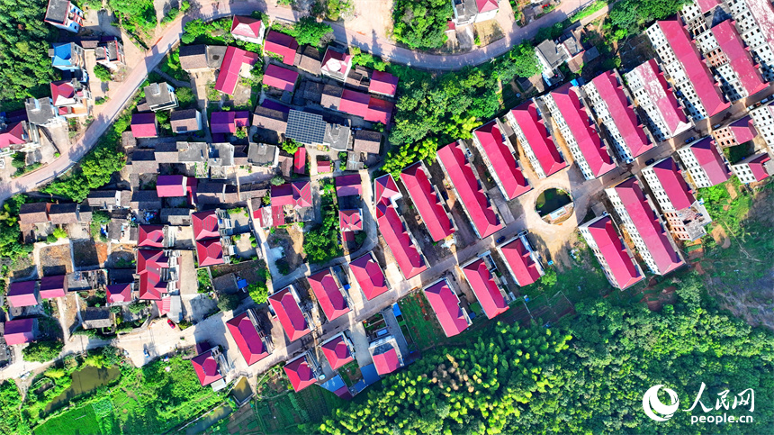 撫州市東鄉區孝崗鎮西源村的農房與通村公路、連綿青山相互映襯，美不勝收。人民網 朱海鵬攝