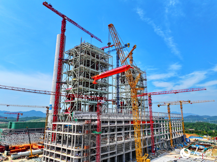 江西贛能上高綜合能源服務項目建設現場塔吊林立，施工人員在吊裝清潔煤電項目1號機組汽機房行車設備。人民網 朱海鵬攝