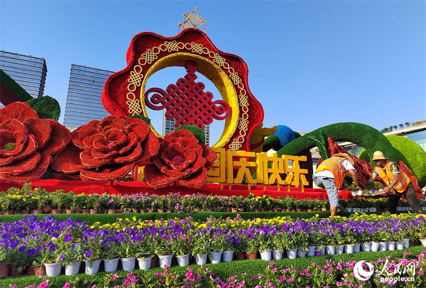 八一廣場上，施工人員正在布置國慶立體花卉造型。人民網記者 時雨攝