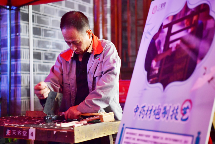 夜市上，非遺傳承人展示中藥材炮制技藝。人民網記者 時雨攝