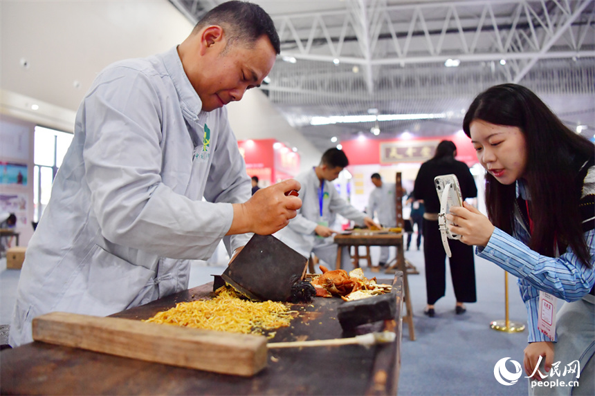第55屆樟樹藥交會活動現場，藥工展示具有樟幫特色的炮制技藝項目。人民網記者 時雨攝