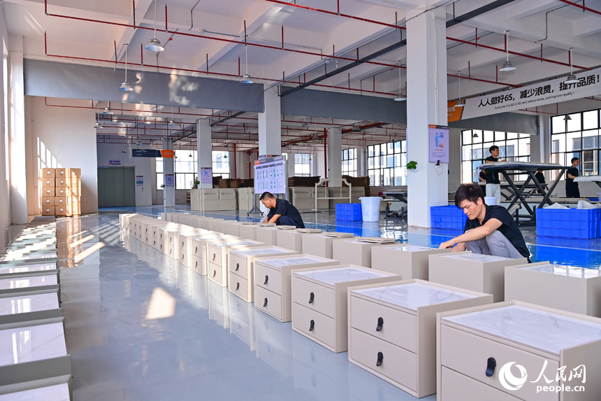 贛州市南康區經濟開發區的一家軟體家具生產企業車間內，工人在加緊制作軟包實木家具。人民網 朱海鵬攝