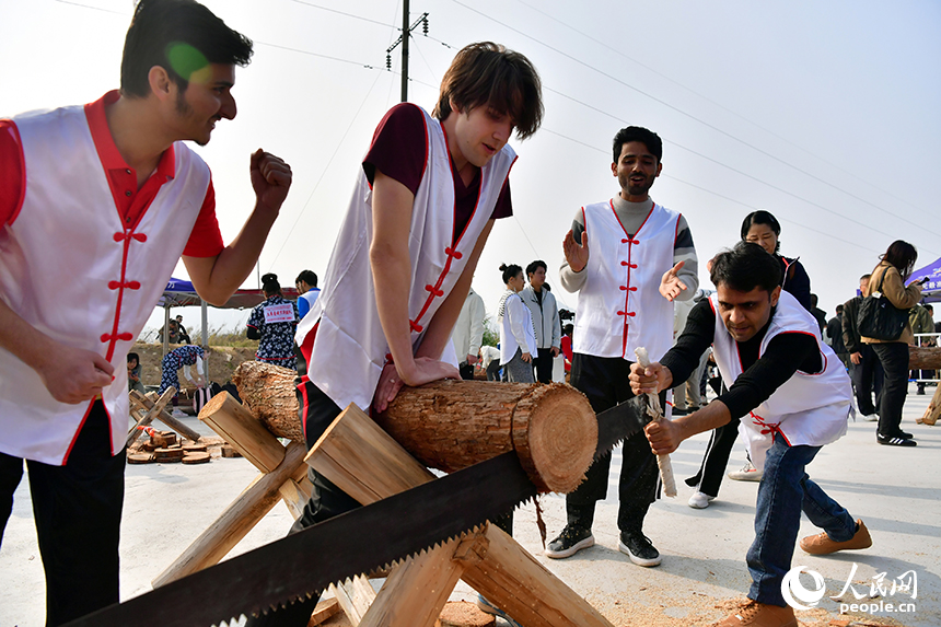 留學生選手們合力完成“同心鋸木”比賽。人民網記者 時雨攝