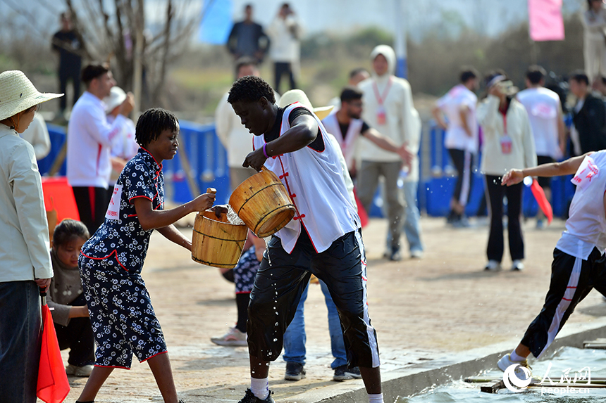 留學生選手們在車水抗旱比賽中轉運水。人民網記者 時雨攝