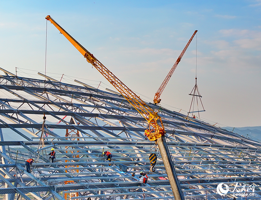 萍鄉市奧體中心項目施工現場，鋼架林立、吊裝繁忙，工人正在加緊建設各類體育場館。人民網 朱海鵬攝