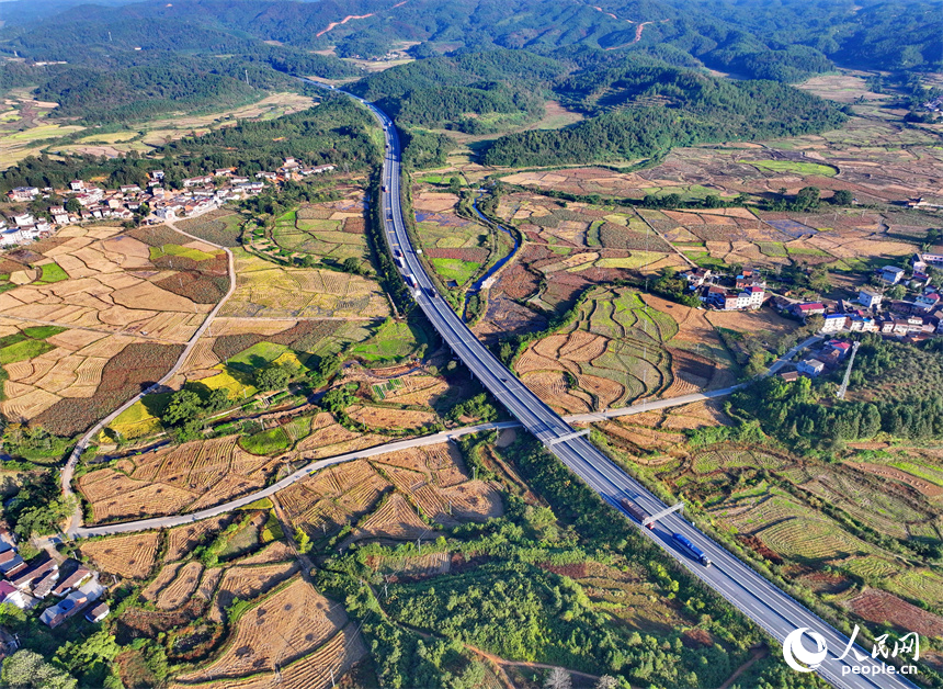 撫州市廣昌縣頭陂鎮塘下村青山掩映、阡陌縱橫，廣吉高速公路上車輛往來行駛。人民網 朱海鵬攝