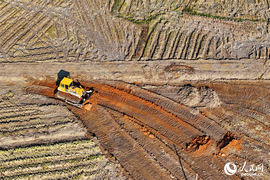宜春市宜豐縣棠浦鎮高標準農田建設點，農機手駕駛推土機進行耕作層表土剝離。人民網朱海鵬攝