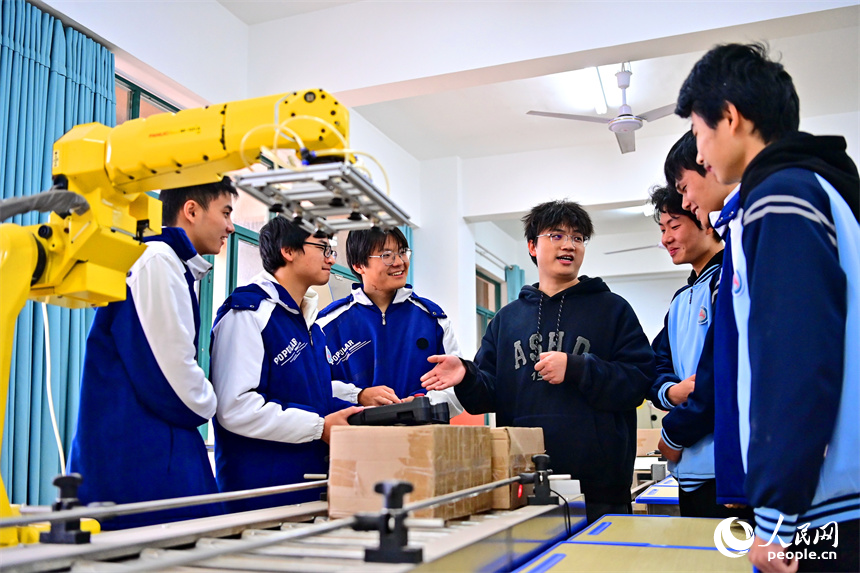 撫州市宜黃縣職業教育中心工業機器人實訓室，學生在學習工業機器人操作流程。人民網 朱海鵬攝