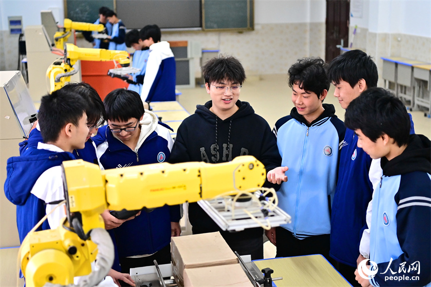 撫州市宜黃縣職業教育中心工業機器人實訓室，學生在學習工業機器人操作流程。人民網 朱海鵬攝