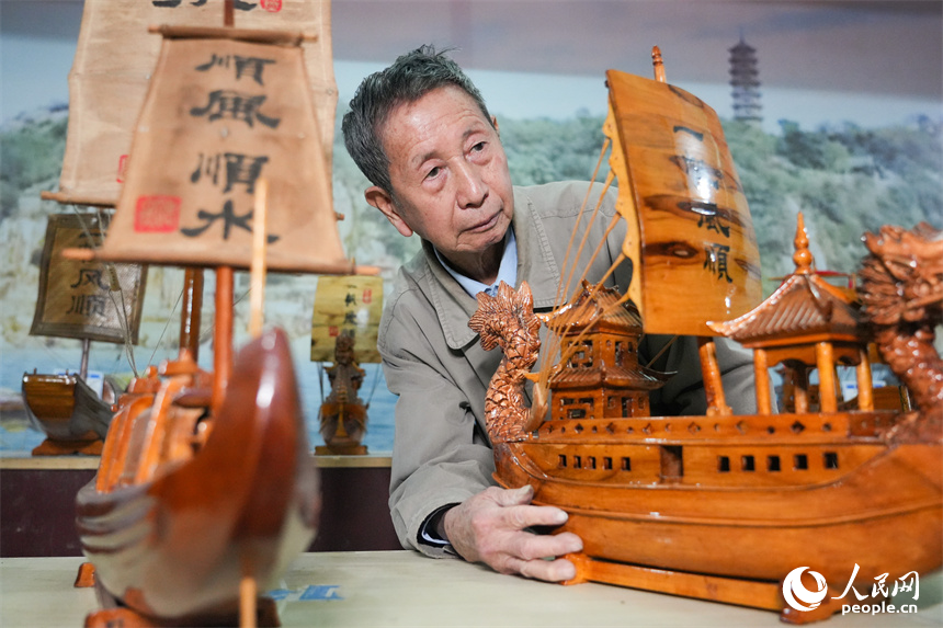 省級非遺項目湖口木船制造技藝傳承人劉興林正在查看船模作品。人民網 孔文進攝
