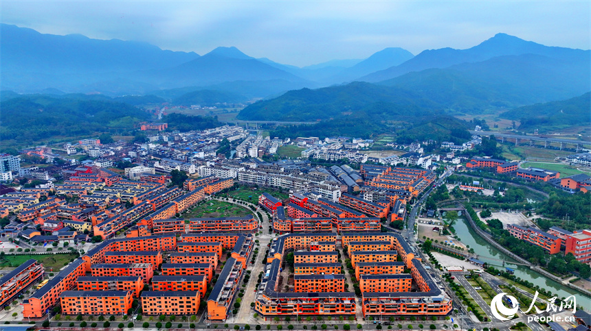 贛州市寧都縣小布鎮，鄉村公路旁的農家房屋整齊排列，與蜿蜒河流、連綿山巒相映成景。人民網 朱海鵬攝