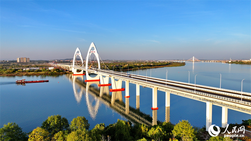 豐城市贛江水域，新建成的紫云大橋與碧水、綠樹、建筑相映成景。人民網 朱海鵬攝
