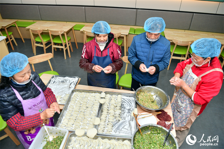 志愿者們忙碌著包餃子。人民網記者 時雨攝
