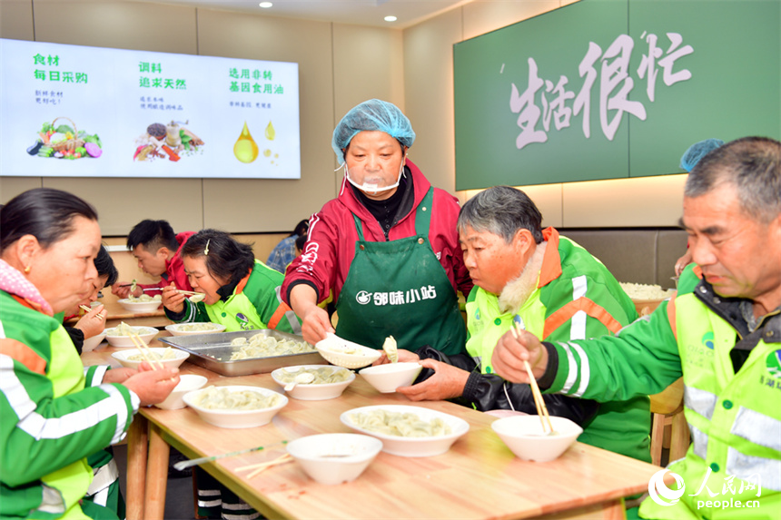 環衛工人和快遞小哥開心地吃餃子。人民網記者 時雨攝