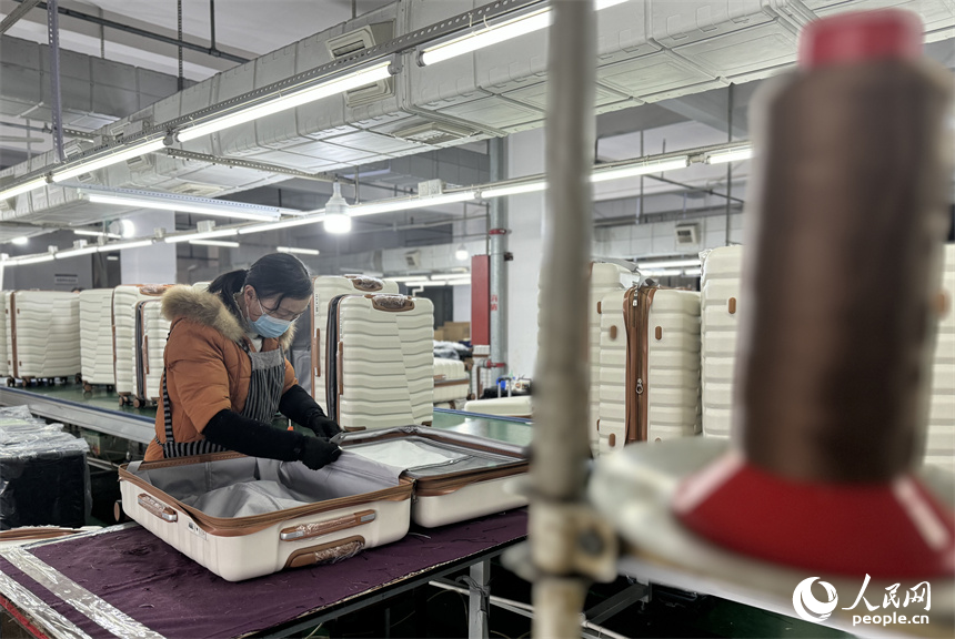 工人們正在生產線上組裝箱包。人民網記者 羅娜攝