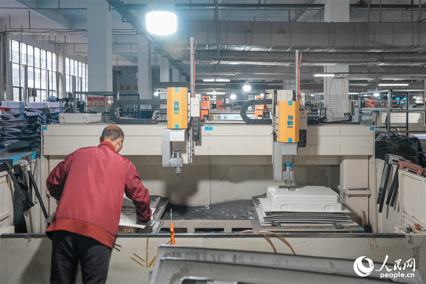 自動化設備在給箱殼鋸邊，打孔。人民網 涂詩軒攝