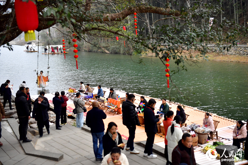 港背村的村民在河邊竹排上售賣山村土特產。人民網記者 時雨攝
