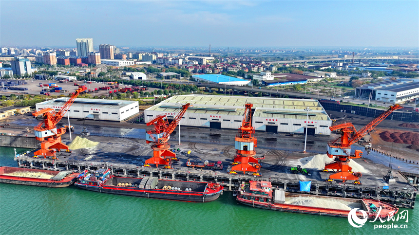 樟樹市樟樹港大碼頭，貨輪、貨車往來穿梭，吊裝運輸作業繁忙有序。人民網 朱海鵬攝