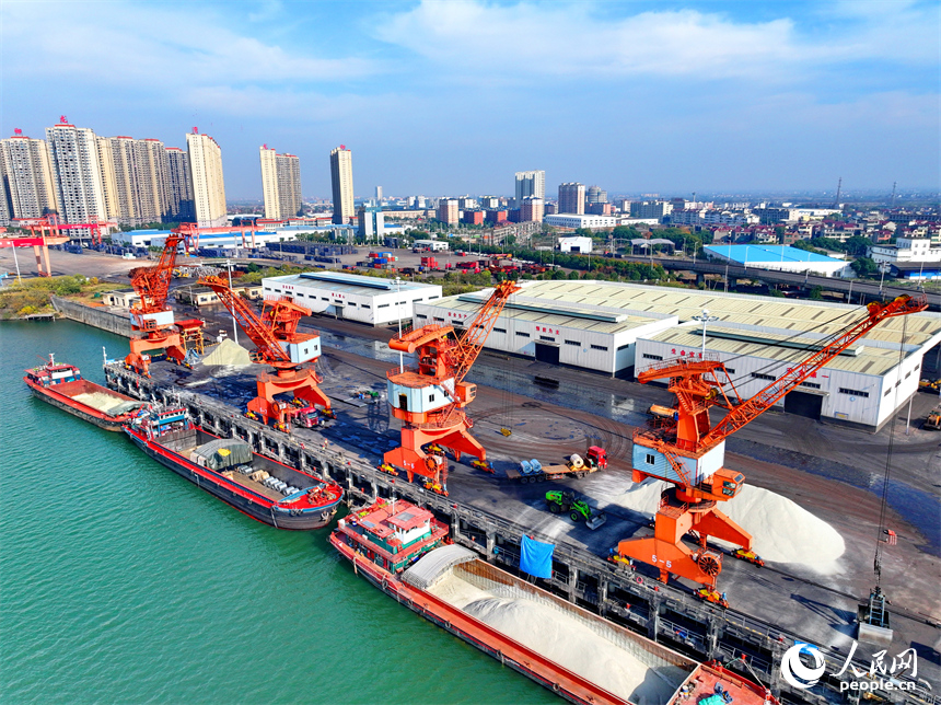 樟樹市樟樹港大碼頭，貨輪、貨車往來穿梭，吊裝運輸作業繁忙有序。人民網 朱海鵬攝