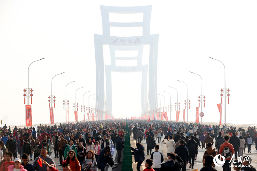 “健步洪州大橋，擁抱幸福生活”南昌市第十三屆迎新健步行活動啟幕。圖為市民和游客行走在洪州大橋上。人民網記者 時雨攝