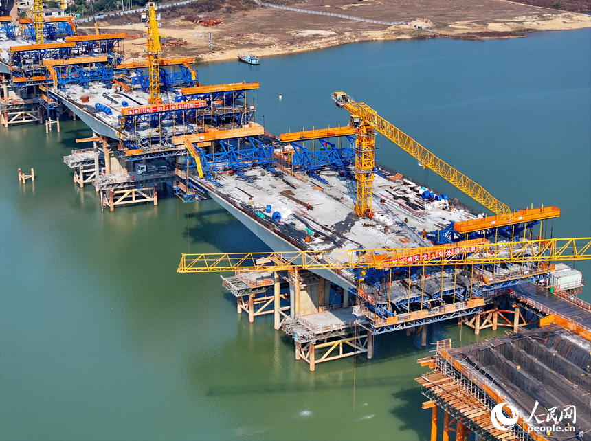 南昌隆興大橋南及連接線工程跨贛江南支引橋建設工地塔吊林立，工人在有序推進橋梁澆筑架設作業。人民網 朱海鵬攝