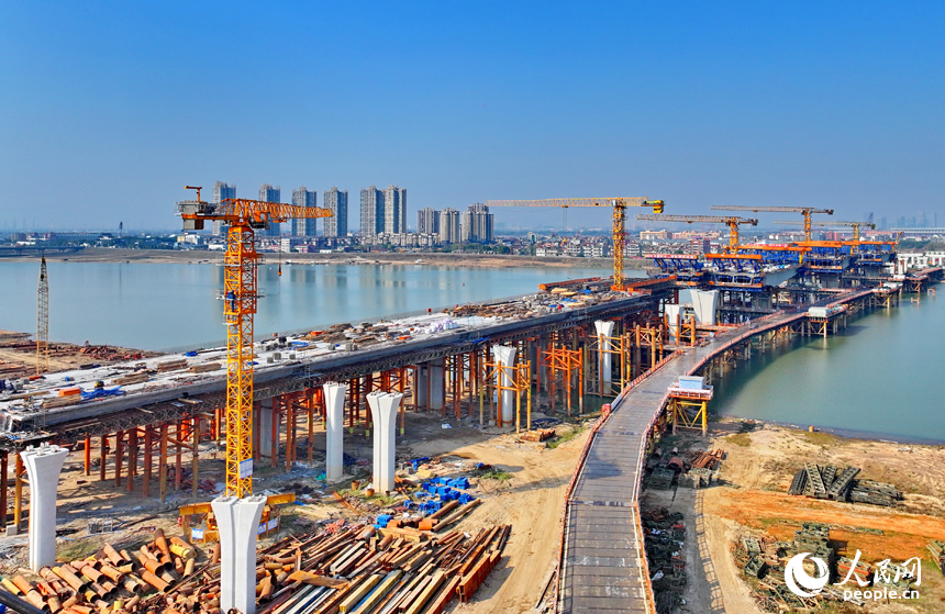 南昌隆興大橋南及連接線工程跨贛江南支引橋建設工地塔吊林立，工人在有序推進橋梁澆筑架設作業。人民網 朱海鵬攝