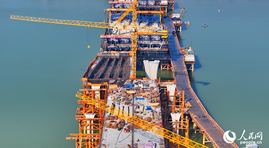 南昌隆興大橋南及連接線工程跨贛江南支引橋建設工地塔吊林立，工人在有序推進橋梁澆筑架設作業。人民網 朱海鵬攝