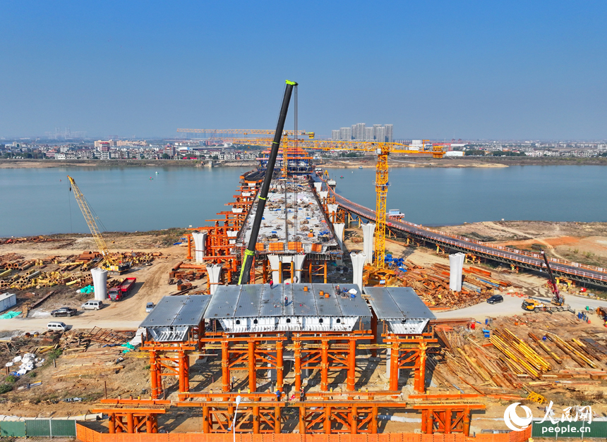 南昌隆興大橋南及連接線工程跨贛江南支引橋建設工地塔吊林立，工人在有序推進橋梁澆筑架設作業。人民網 朱海鵬攝