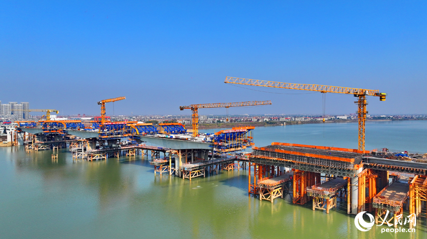 南昌隆興大橋南及連接線工程跨贛江南支引橋建設工地塔吊林立，工人在有序推進橋梁澆筑架設作業。人民網 朱海鵬攝