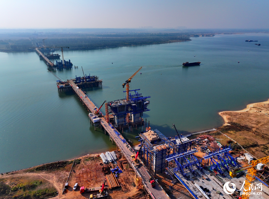 昌南大橋項目施工現場塔吊林立、機械轟鳴，工人在加緊推進橋梁承臺和引橋建設。人民網 朱海鵬攝